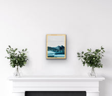 Load image into Gallery viewer, Painting of a blue mountain scene, hanging in a natural wood frame
