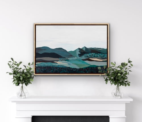 Original abstract mountain painting, hanging above a fireplace in a natural wooden canvas floater frame.